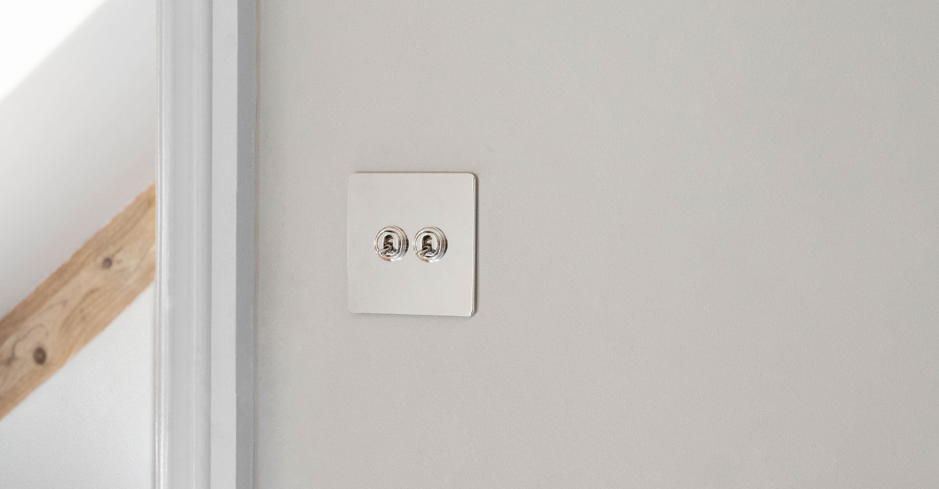 2 toggle switch in polished nickel on white wall